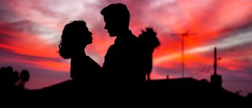 silhouette of man and woman facing each other during golden hour