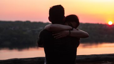 couple hugging each other during sunset